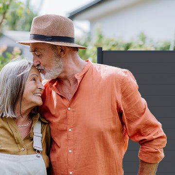 Paar vor einem Sichtschutzzaun